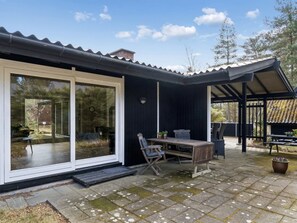 Une maison moderne dotée d’un patio, d’un coin repas et d’un espace extérieur couvert.