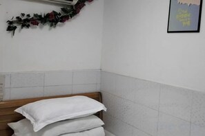 A bathroom with a wooden bench, white towels, and a framed quote on the wall. - Zhenghong Hostel (Shanghai)