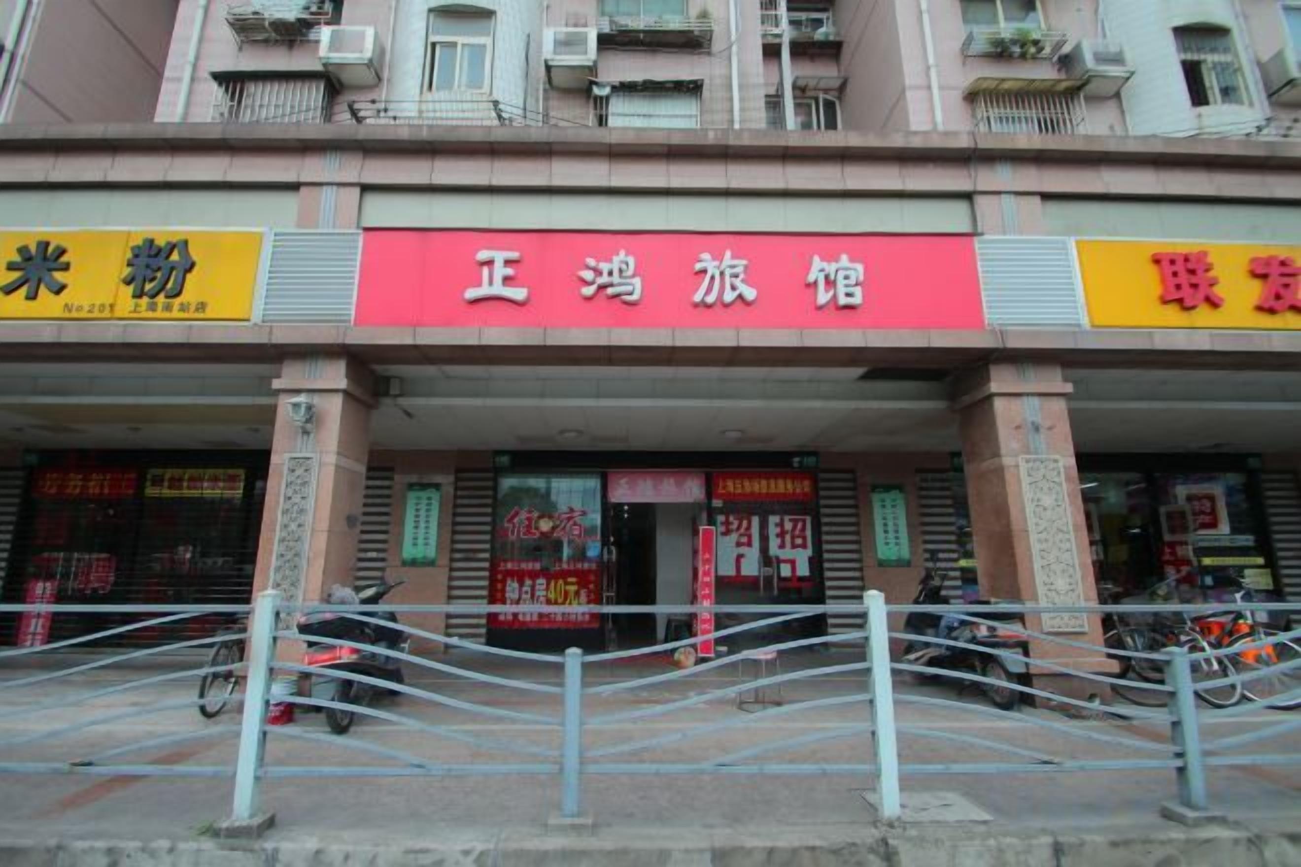 A building with multiple storefronts, including a red sign for a restaurant and a yellow sign for a grain store.