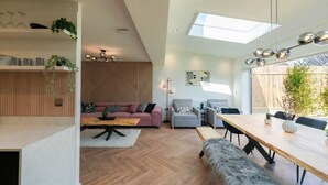 A modern living space with a loft bedroom, a dining area, and a kitchen. - Luxury 8 Bed Home Manchester (Manchester)