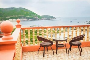 A balcony with a view of the sea, two wicker chairs, and a small table. - Shengsi Haiyi Lanting Homestay (Shengsi)