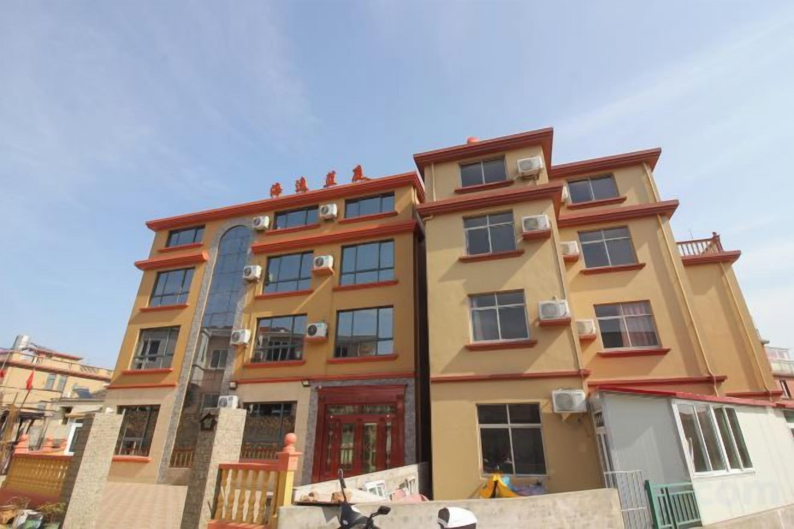 A multi-story building with a red door and multiple windows.