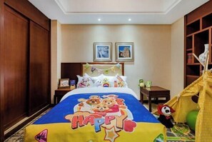 Un dormitorio con cama, mesita de noche, una pequeña mesa, una tienda de campaña y cuadros en la pared.