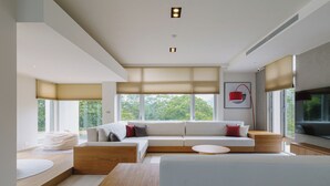 A modern living room with a large sectional sofa, a wooden coffee table, and a flat-screen TV mounted on the wall. - The O Villa Jiaoxi (Jiaoxi)