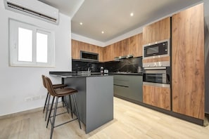 Enjoy cooking in this well-equipped kitchen with a sleek island, microwave, and stainless steel oven.