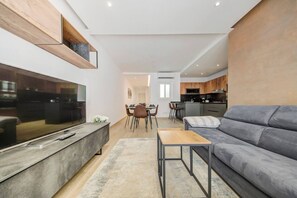 Relax in this spacious living area with a large flat-screen TV, comfortable sofa, and dining space for four.