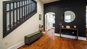 A staircase with a black railing, a bench, a console table with candles, and a mirror on the wall. - 1 Mile to Downtown -Brewers Hill-Rooftop Deck-Gym (Milwaukee)