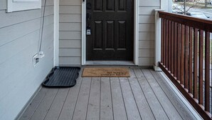 A porch with a dark wooden door, string lights, and a doormat. - 1 Mile to Downtown -Brewers Hill-Rooftop Deck-Gym (Milwaukee)
