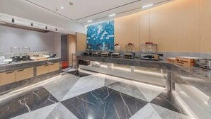 Een moderne hotellobby met een receptiebalie, een betegelde muur en een marmeren vloer.