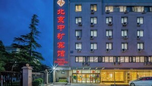 A hotel building with a prominent sign in red characters, multiple windows, and air conditioning units. - Beijing ZhongKuang Hotel (Beijing)