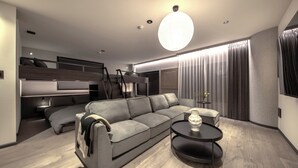 Un salon moderne avec un canapé, une table basse et un escalier menant à une mezzanine.