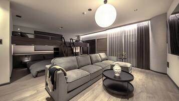 Habitación cuádruple familiar | Zona de estar | Smart TV de 62 pulgadas con canales digitales