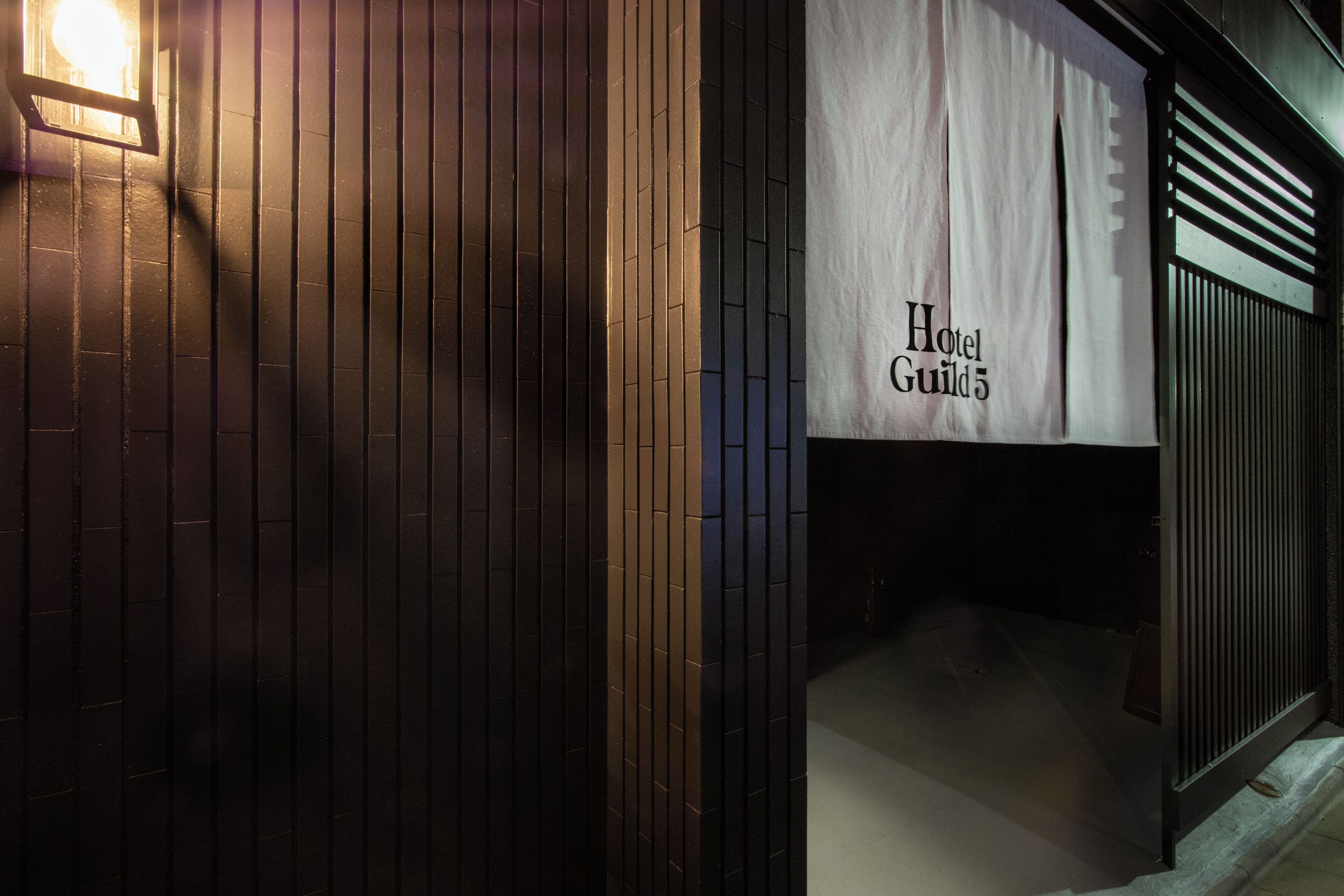 Een gevel met een bord waarop 'Hotel Guild 5' staat.