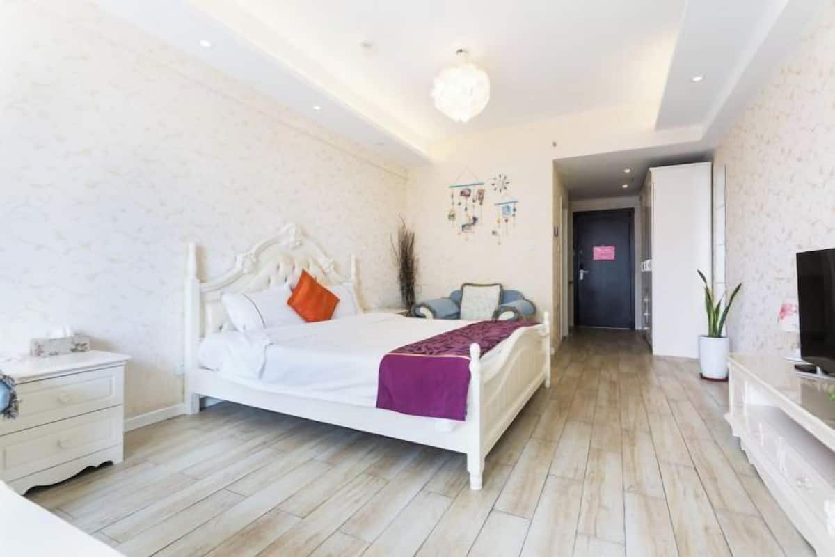 Ein Schlafzimmer mit Bett, Nachttisch und Fernseher.