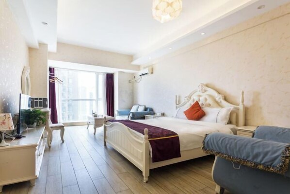 A modern hotel room with a large bed, bedside tables, a desk, and a chair.