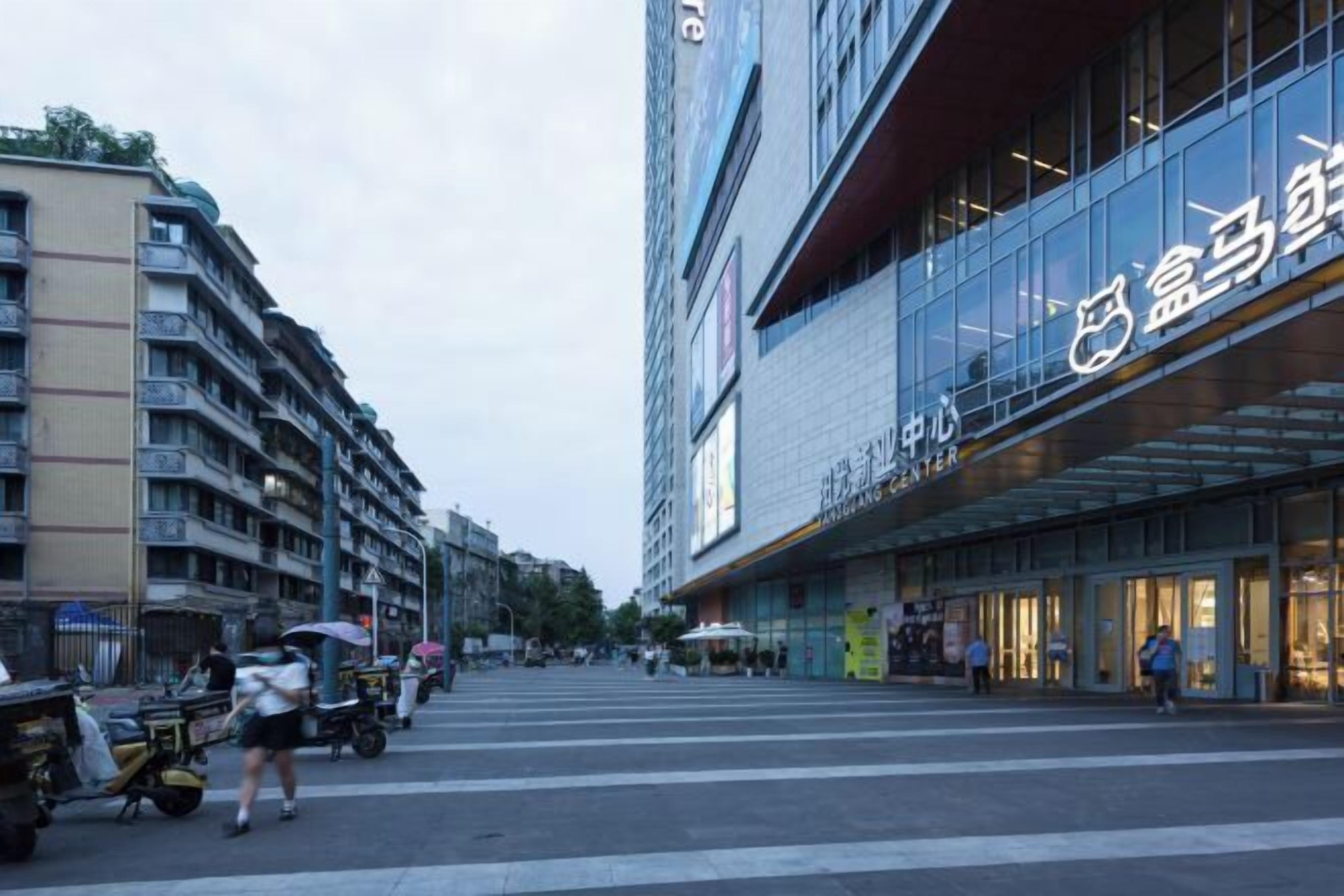 A modern building with a glass facade and signage indicating a shopping center.
