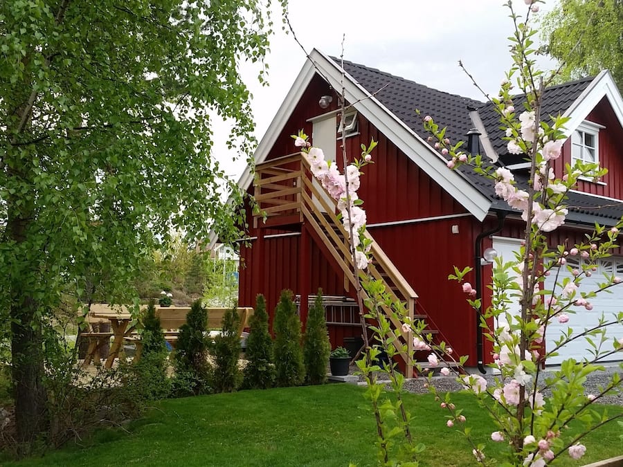 Une maison rouge avec un escalier en bois menant au garage.