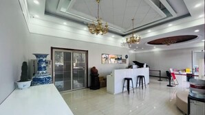 Un hall d’hôtel moderne comprenant un comptoir d’accueil, un bar et un espace salon.