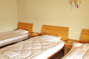 A room with three single beds, wooden headboards, and bedside tables with lamps. - Xuancheng Airitang Inn (Jing County)