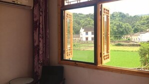 A room with a window, a chair, and a small table. - Xuancheng Airitang Inn (Jing County)