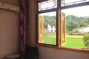 A room with a window, a chair, and a small table. - Xuancheng Airitang Inn (Jing County)