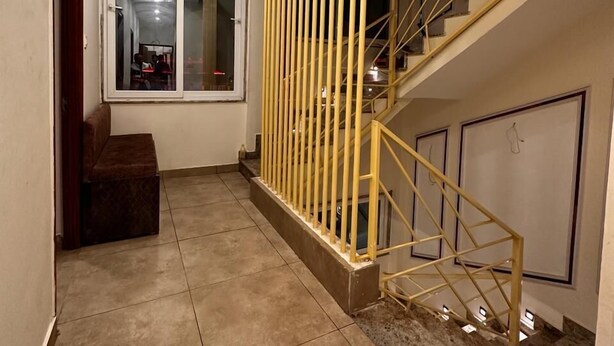A modern interior with a staircase, a bench, and a view through a window. - Sri Madhav Stay (Varanasi)