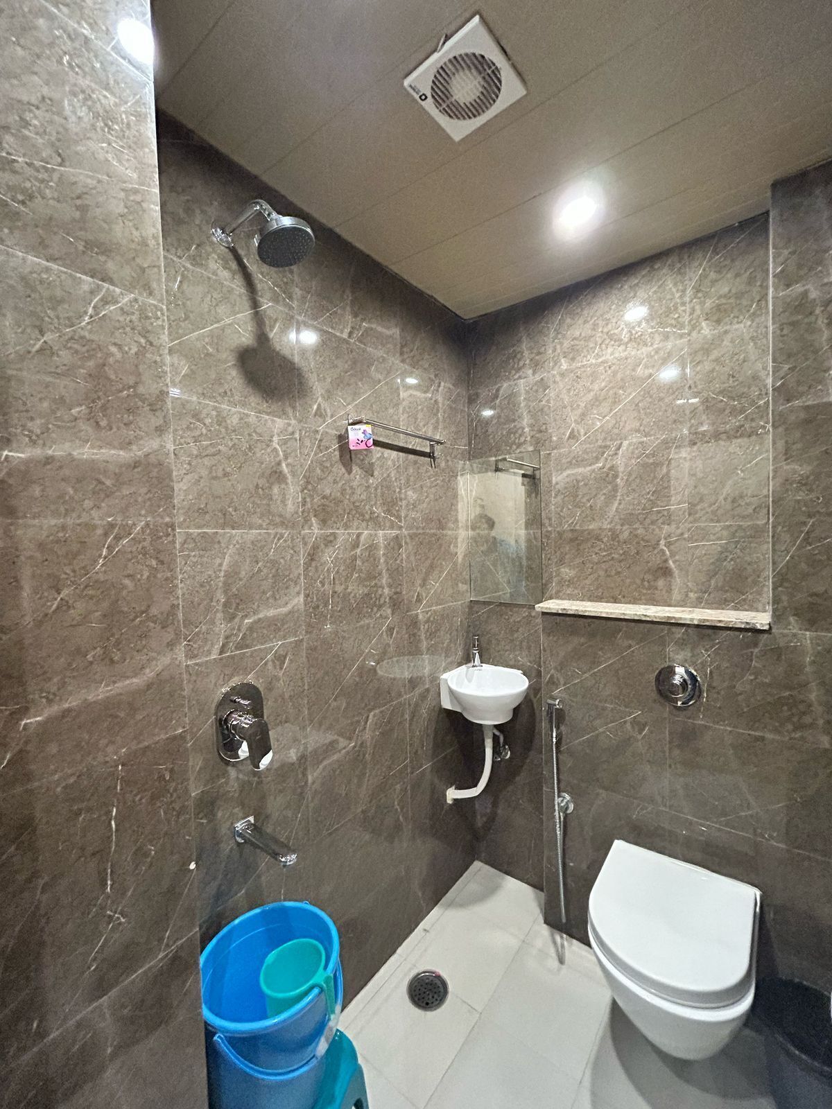 A modern bathroom with a shower, sink, and toilet.