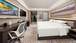 A modern hotel room with a large bed, a desk with a chair, a flat-screen TV, and artwork on the walls. - Lavande Hotel (Tianjin Binhai Yujiabao Financial Center) (Tianjin)