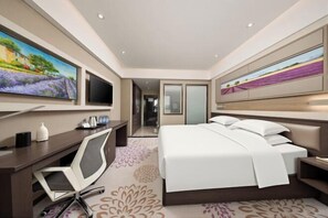 A modern hotel room with a large bed, a desk with a chair, a flat-screen TV, and artwork on the walls. - Lavande Hotel (Tianjin Binhai Yujiabao Financial Center) (Tianjin)
