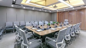 A conference room with a long table, chairs, and a projector.