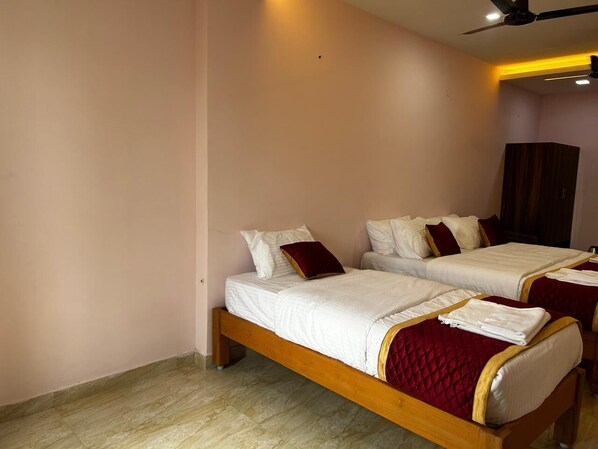 A room with two single beds, each with white bedding and red accents. - J V Residency (Salem)