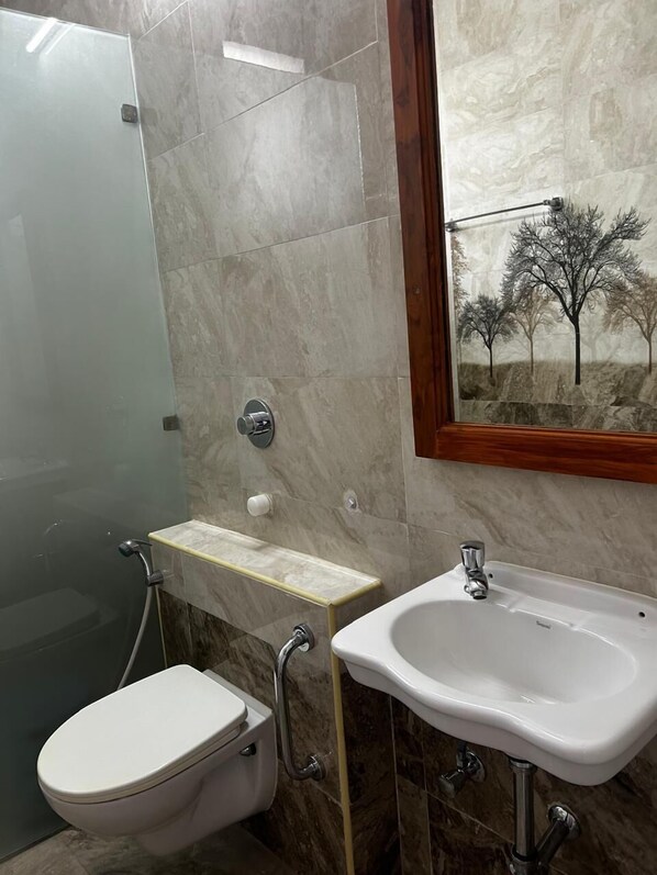 A bathroom with a toilet, shower, and sink. - J V Residency (Salem)