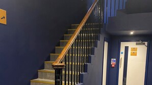 Una escalera con barandillas de madera y peldaños alfombrados.