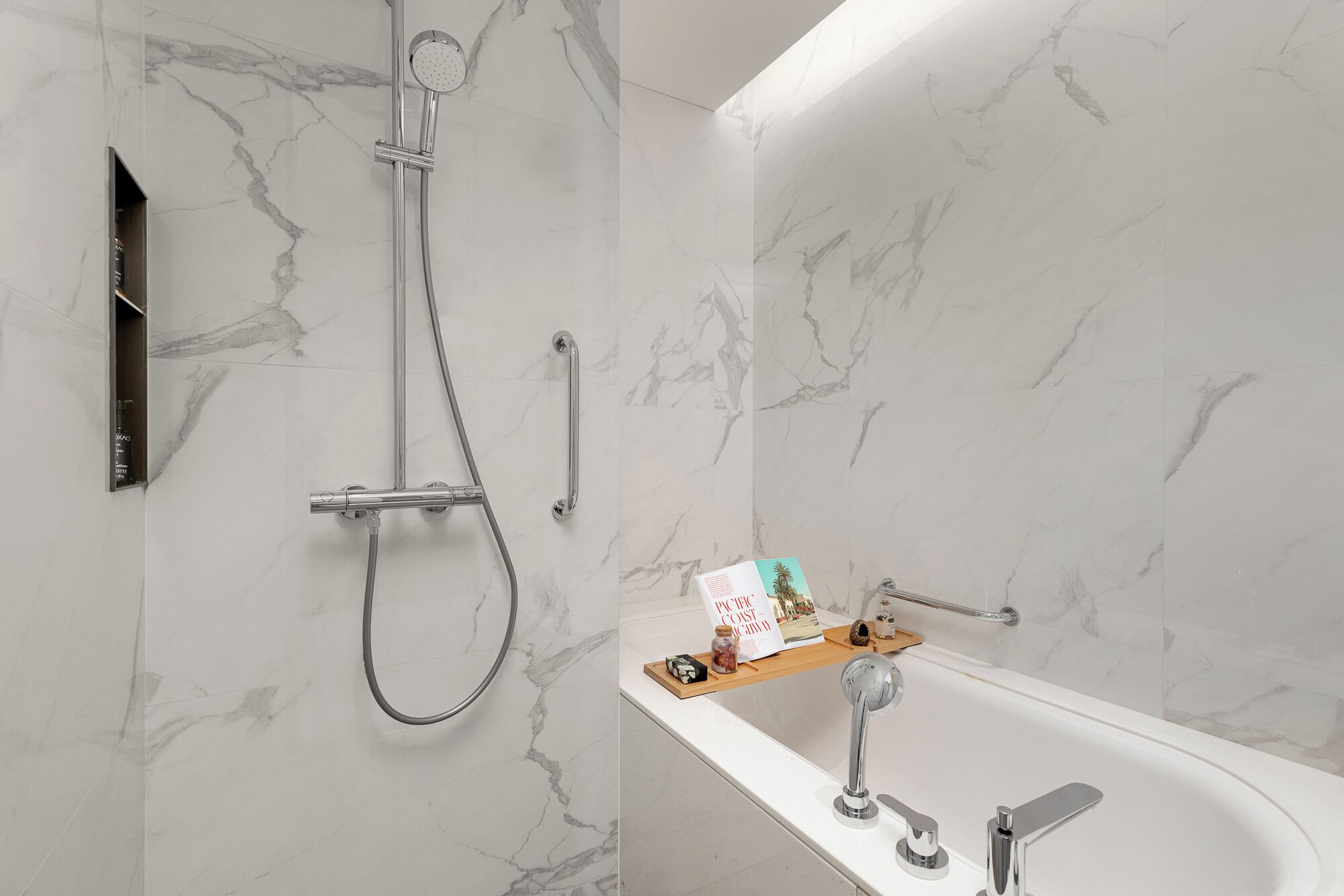 A modern bathroom with a shower, a bathtub, and a marble wall.