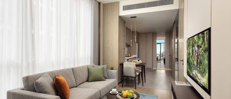 A modern living room with a sofa, a coffee table with fruit, a TV, and a view of the city.