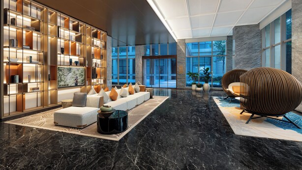 A modern lobby with a sectional sofa, a black coffee table, and a unique woven chair. There is a large bookshelf and a view of the outdoors through large windows. - Somerset Qplex Shenzhen (Shenzhen)