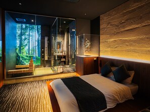 A modern bedroom with a large bed, a glass shower enclosure, and a view of a forest. - Giraffe Tenjin Tsune (Fukuoka)