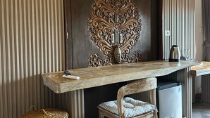 A modern kitchen with a wooden countertop, a built-in stove, and a decorative wall panel. - Mandala Homestay  (Ubud)