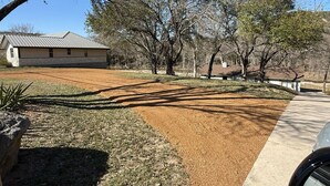 A residential property with a house, a paved driveway, and a landscaped area with trees and shrubs. - The Hidden Cove on the Horseshoe (Canyon Lake)
