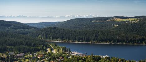 Ein Dorf am See mit Häusern, einer Kirche und Blick auf die Berge.