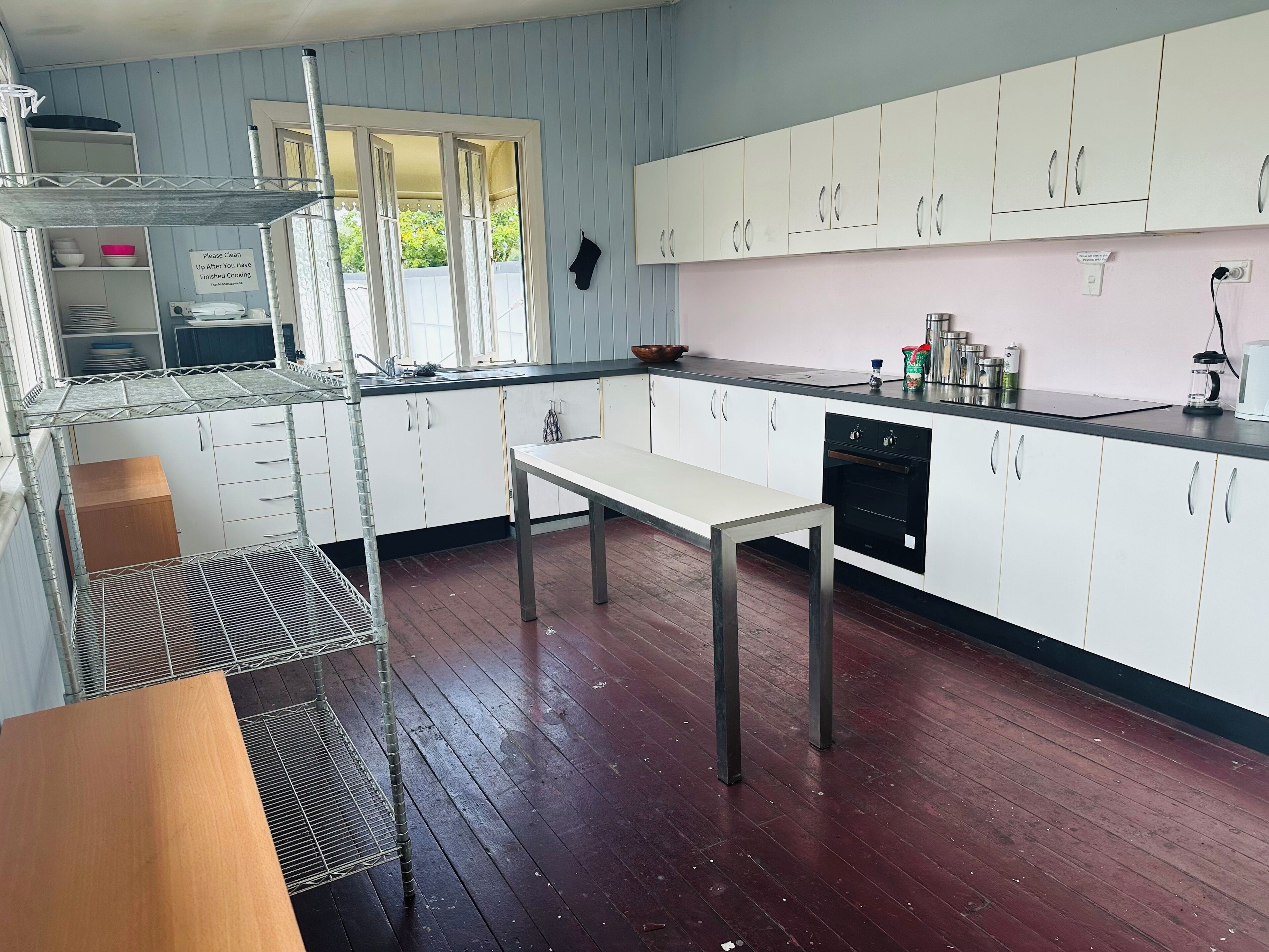 A kitchen with white cabinets, a black countertop, and a wooden table.