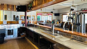 Eine Bar mit Zapfhahn-Theke, einem Spiegel und einem Schild für die Toilette.
