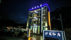 Un hotel con fachada moderna, señalización iluminada y una entrada bien iluminada.