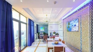 Un comedor moderno con un ventanal grande, una araña y una pared de azulejos con un cuadro decorativo.
