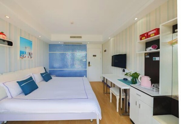 Une chambre d’hôtel équipée d’un lit, d’un bureau, d’une télévision et d’une fenêtre donnant sur un paysage agréable.