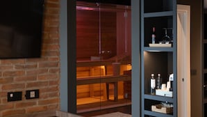 Ein modernes Wohnzimmer mit Backsteinwand, einer Glastrennwand und einer Holztreppe.