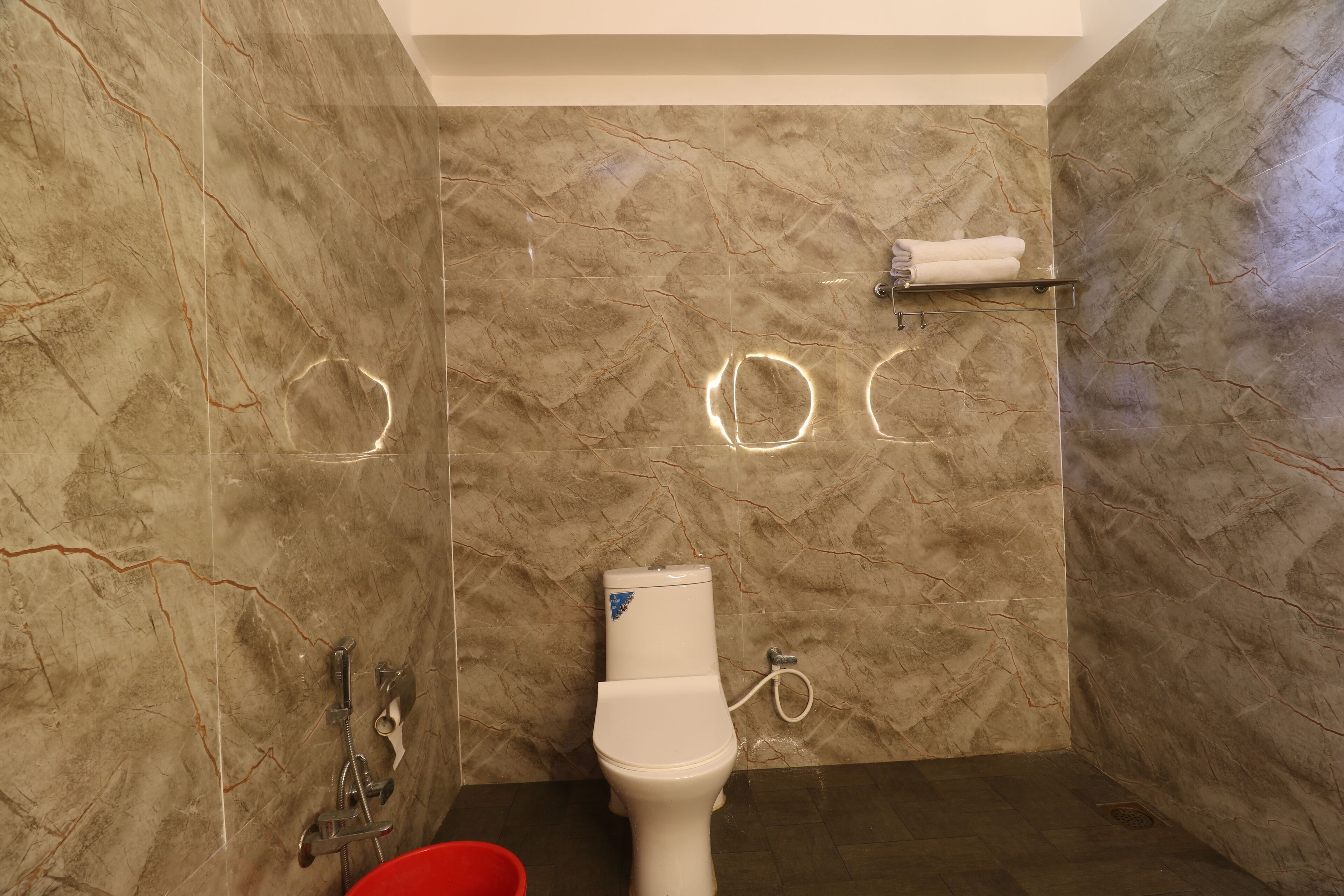 A bathroom with a toilet, shower, and a towel rack.