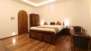 A bedroom with a wooden bed, a nightstand, a chair, and a wardrobe.