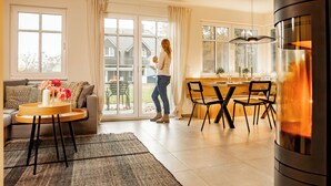 A modern living room with a sofa, coffee table, and a dining area with chairs and a table. - Lieblingshof House 4 - Holidays between the Baltic Sea and the Bodden (Born a. Darß)