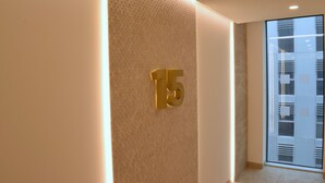 Ein Flur mit einer strukturierten Wand und einem großen, goldenen Schild mit der Zahl 15.